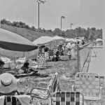 line of umbrellas and tables on side opposite clubhouse